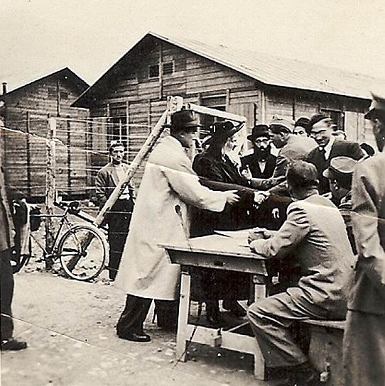 Георг Мандель (первый слева, в белом пальто) уговаривает швейцарских пограничников впустить венгерского раввина, 7 декабря 1944 года