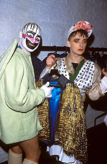 Ли Бауэри (слева) и Бой Джордж на модном показе в Театре Олбери, 1988. Бауэри был автором сценических костюмов Бой Джорджа и считается «крестной» музыкальной сцены «новых романтиков», возникшей в Англии в 1980-х в противовес панку 