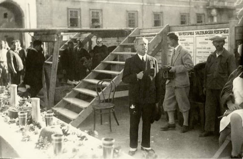 Макс Рейнхардт на репетиции возобновления спектакля «Jedermann» на Соборной площади в Зальцбурге; слева в глубине — актер Алоис Райнер в маске Смерти, одного из главных персонажей пьесы. 1930