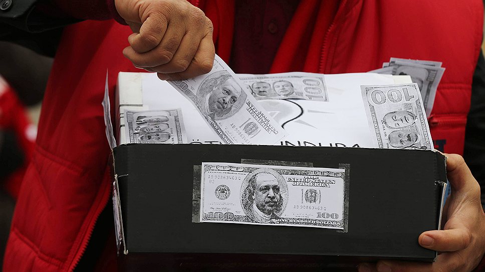 Коробка из-под обуви с &quot;долларами&quot;, ставшая символом коррупционного скандала, в руках у участника многотысячной демонстрации протеста в Анкаре 11 января 2014 года