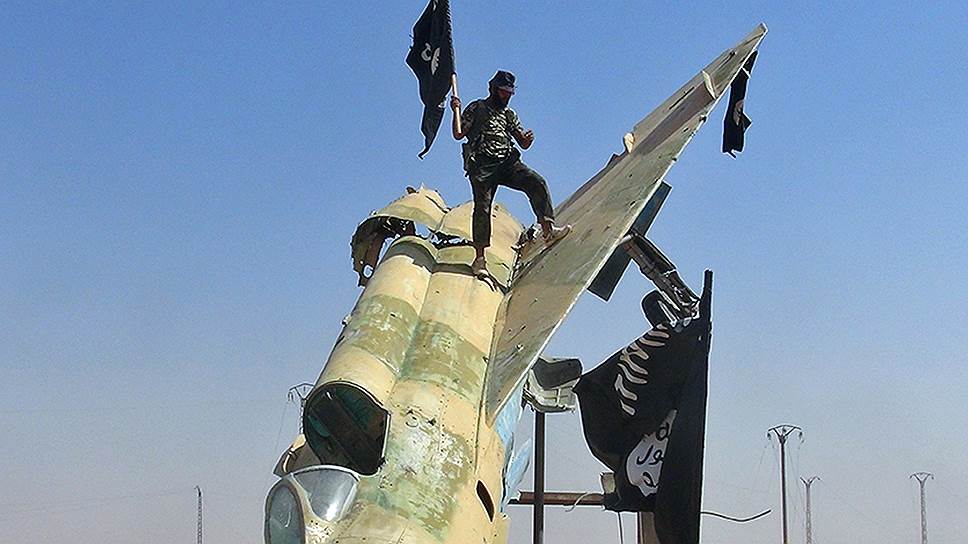 Бойцы ИГИЛ на обломках истребителя правительственной Сирийской арабской армии после боев за авиабазу Табка в провинции Ракка 
