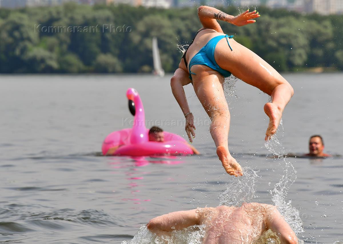 Купание в москве реке. Мужчина на пляже Строгино. Спорт и жара фото.