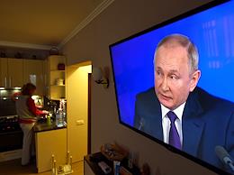 Genre photography. People listen and watch the Big Annual Press Conference of Russian President Vladimir Putin.