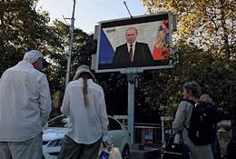 People on the street watch and listen to President Vladimir Putin's speech on joining Russia with the Donetsk and Luhansk People's Republics, as well as the Kherson and Zaporozhye regions, on Nakhimov Square.