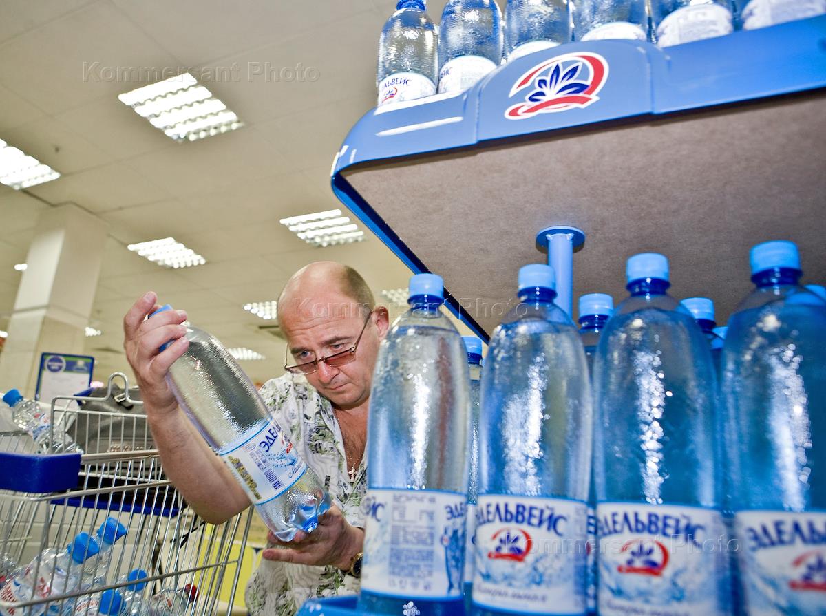 На столе поставлены в ряд бутылка минеральной воды